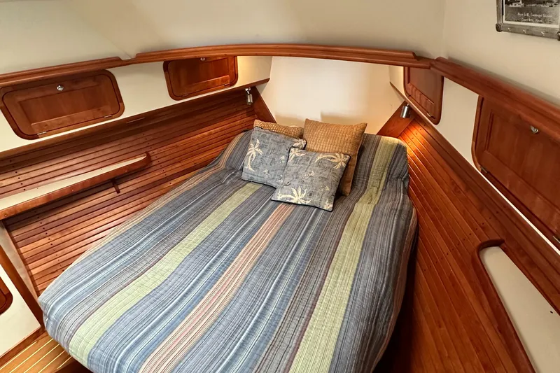 Blue Sora Yacht Photos Pics Cozy cabin interior of 2005 Legacy 42 yacht with striped bedding and wooden accents.