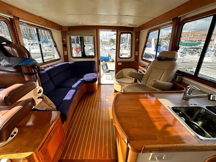 Blue Sora Yacht Photos Pics Luxurious interior of a 2005 Legacy 42 yacht with plush seating and wooden finishes.