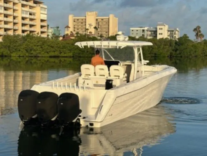  Yacht Photos Pics 2017 Stamas 390 Tarpon boat cruising on calm water near buildings and greenery.