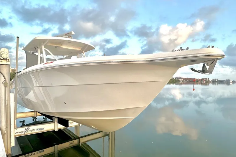  Yacht Photos Pics 2017 Stamas 390 Tarpon boat on lift, reflecting on calm water under cloudy sky.