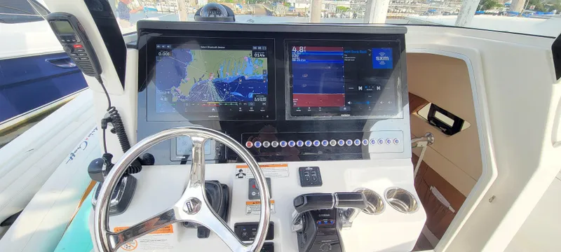  Yacht Photos Pics 2018 Edgewater 370CC boat dashboard with navigation screens and steering wheel.