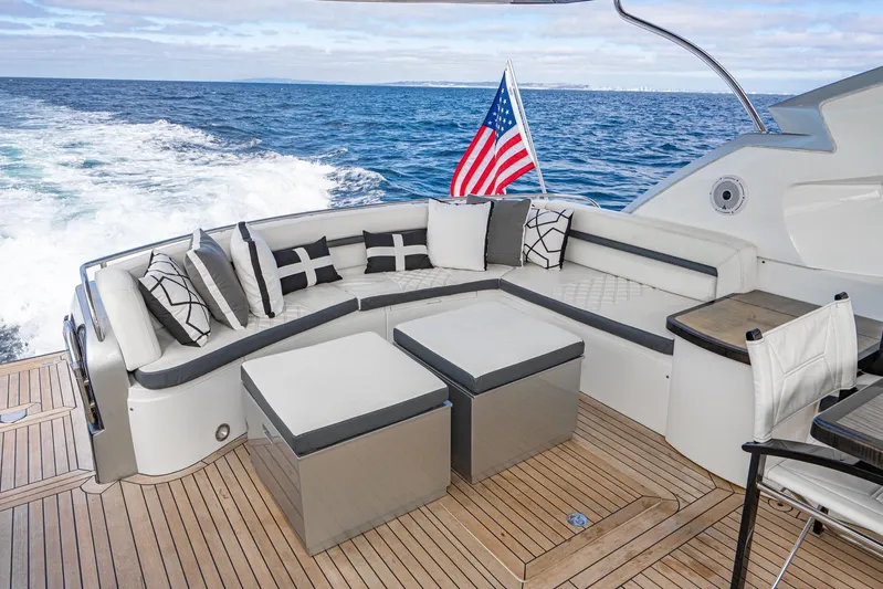  Yacht Photos Pics Luxurious Sunseeker Predator 68 yacht deck with elegant seating, ocean view, and American flag.