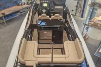 2022 Zar Formenti 85 SL boat interior with beige seating and modern dashboard in a workshop.