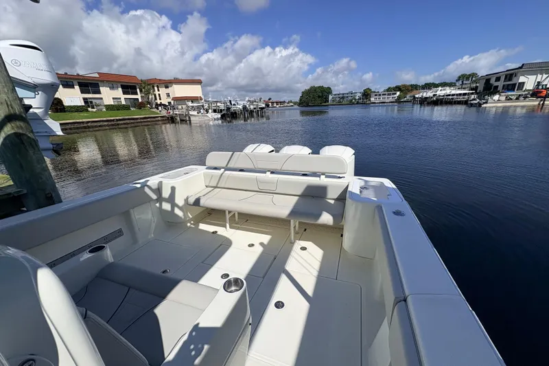 Bluefin Yacht Photos Pics 2017 SeaVee 370Z boat interior with seating, docked by waterfront buildings.
