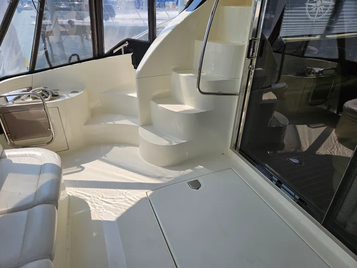 Bella Vita Yacht Photos Pics Interior view of 2003 Azimut 46 MY yacht with white seating and spiral staircase.