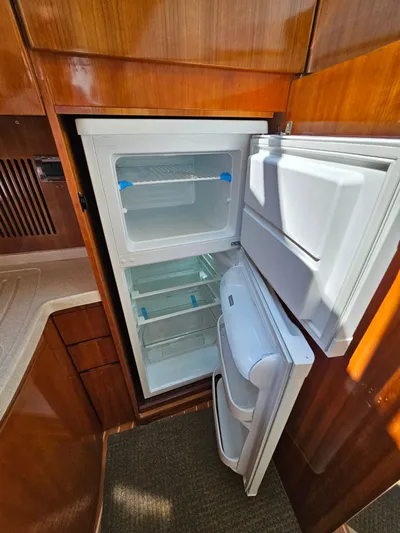 Bella Vita Yacht Photos Pics Open refrigerator inside 2003 Azimut 46 MY yacht, featuring wooden cabinetry and modern design.