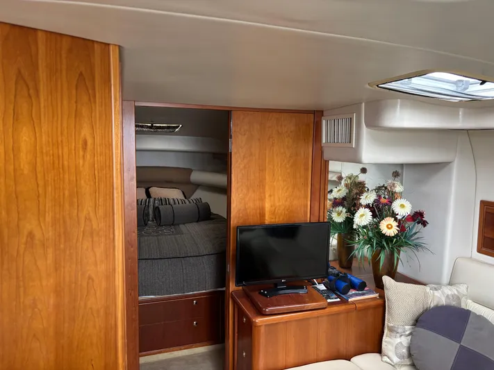  Yacht Photos Pics Interior of 2004 Riviera 4000 yacht with cozy bedroom, TV, and floral arrangement.