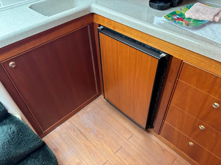  Yacht Photos Pics 2004 Riviera 4000 yacht interior with wooden cabinetry and compact fridge.