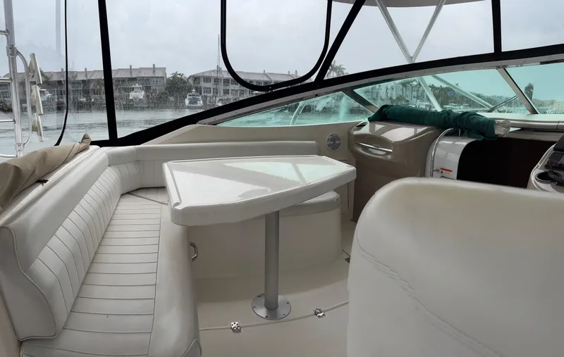  Yacht Photos Pics Interior of a 2004 Riviera 4000 yacht with white seating and a triangular table.