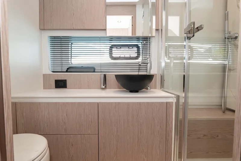 II Zoes Yacht Photos Pics Modern bathroom interior of 2023 Azimut Fly 53 yacht with sleek design and wooden finishes.