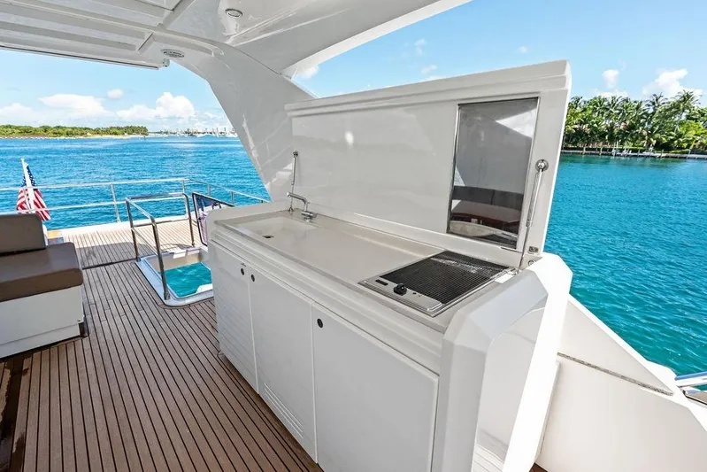 Elevation Yacht Photos Pics Luxury yacht deck with outdoor kitchen, Prestige 750, 2016 model, overlooking serene blue waters.