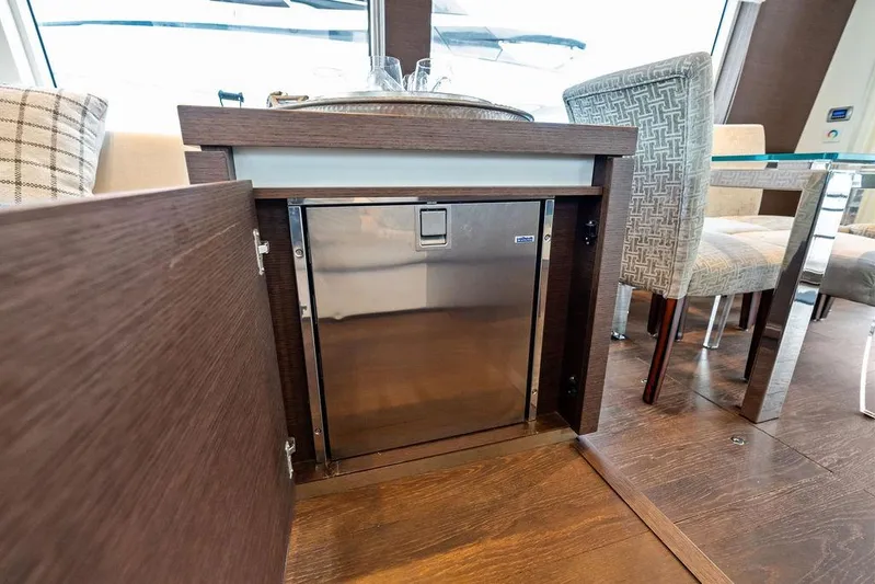 Elevation Yacht Photos Pics Luxury yacht interior with open cabinet, stainless steel appliance, and elegant dining area, Prestige 750, 2016.