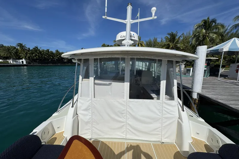 Swell Yacht Photos Pics 2020 Back Cove 34O boat docked, featuring enclosed cockpit and scenic waterfront view.