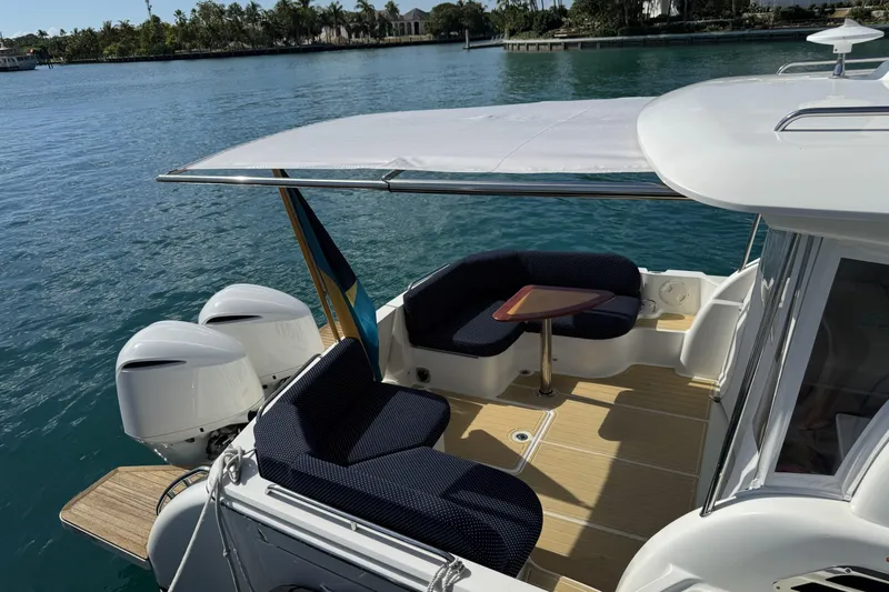 Swell Yacht Photos Pics 2020 Back Cove 34O boat with seating area and twin outboard engines on calm water.
