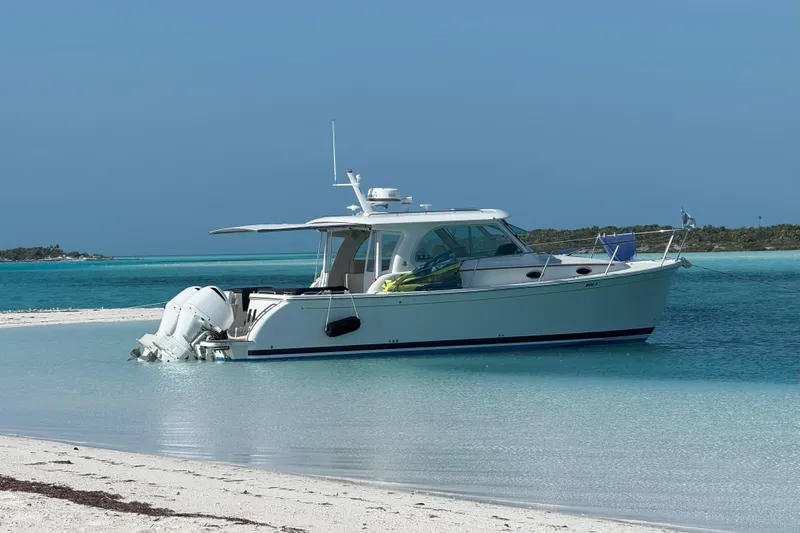 Swell Yacht Photos Pics 2020 Back Cove 34O boat anchored on a sandy beach with turquoise water.