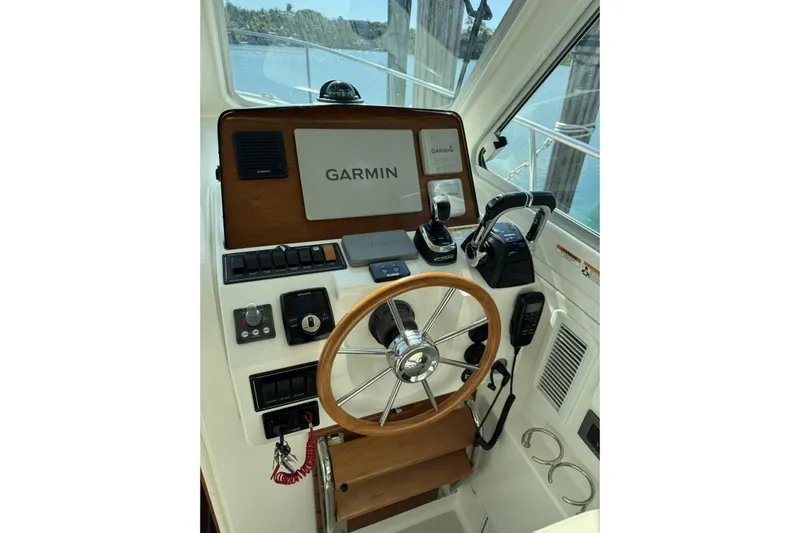 Swell Yacht Photos Pics 2020 Back Cove 34O helm with Garmin navigation, wooden steering wheel, and control panel.