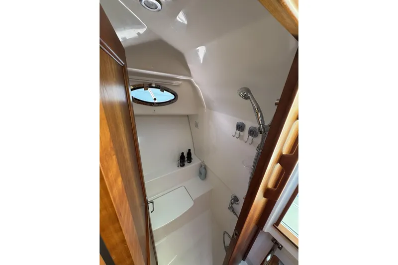 Swell Yacht Photos Pics 2020 Back Cove 34O yacht bathroom with shower, wooden accents, and porthole window.