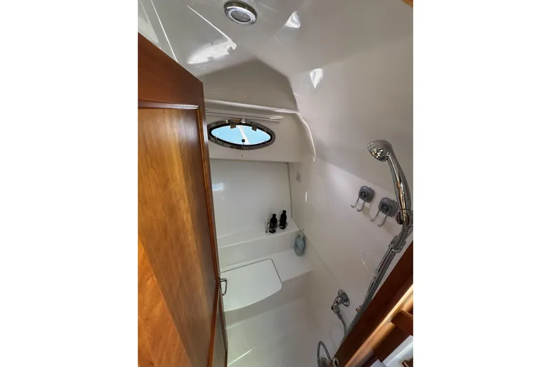 Swell Yacht Photos Pics 2020 Back Cove 34O yacht bathroom with shower, wooden door, and porthole window.