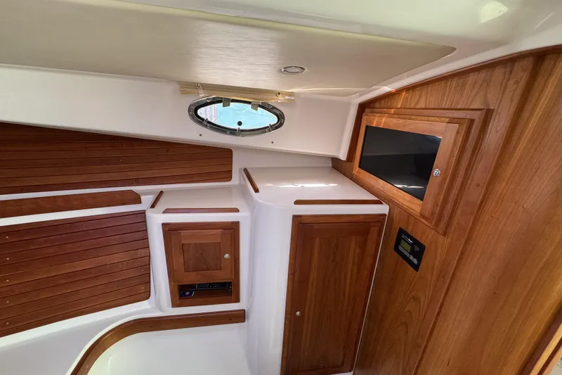 Swell Yacht Photos Pics 2020 Back Cove 34O cabin interior with wood paneling and porthole window.
