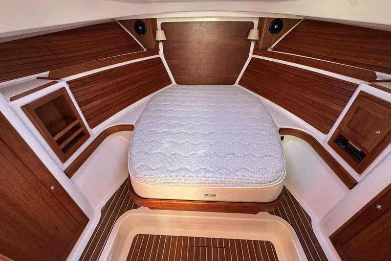 Swell Yacht Photos Pics 2020 Back Cove 34O cabin interior with wooden paneling and a comfortable bed.