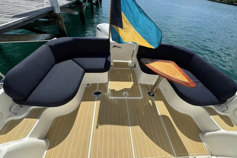 Swell Yacht Photos Pics 2020 Back Cove 34O boat deck with seating and table, docked by the water.