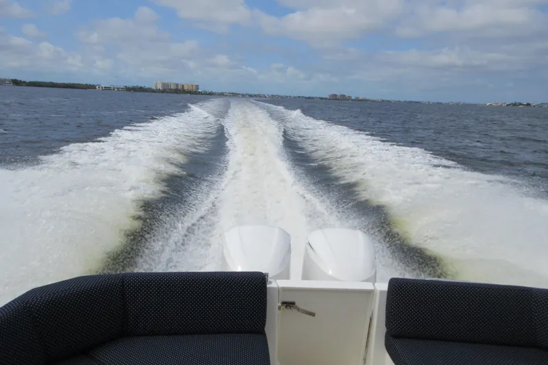 Swell Yacht Photos Pics Wake trail behind 2020 Back Cove 34O boat on open water under cloudy sky.