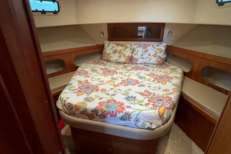 Mary Jean Too Yacht Photos Pics Cozy bedroom in 2003 Mainship 430 Trawler with floral bedding and wooden accents.