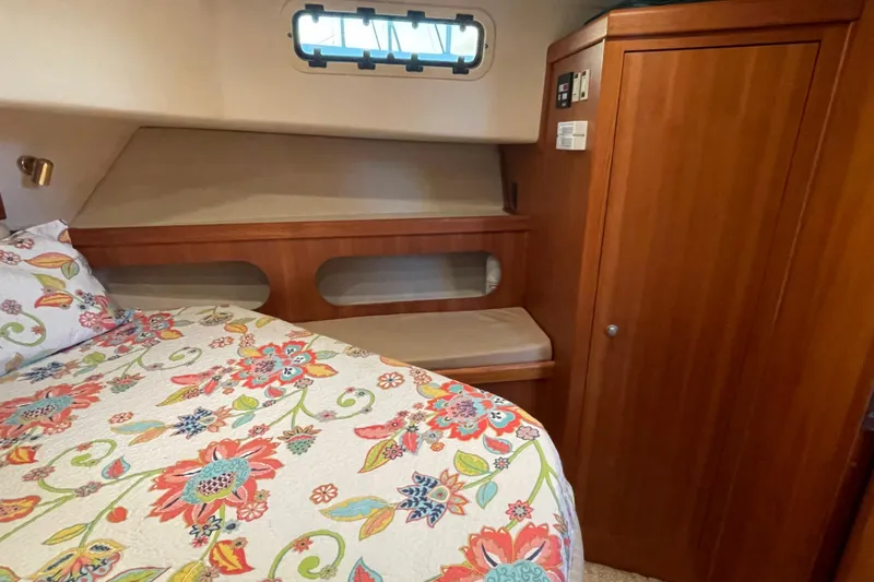 Mary Jean Too Yacht Photos Pics Cozy cabin interior of 2003 Mainship 430 Trawler with floral bedding and wooden cabinetry.
