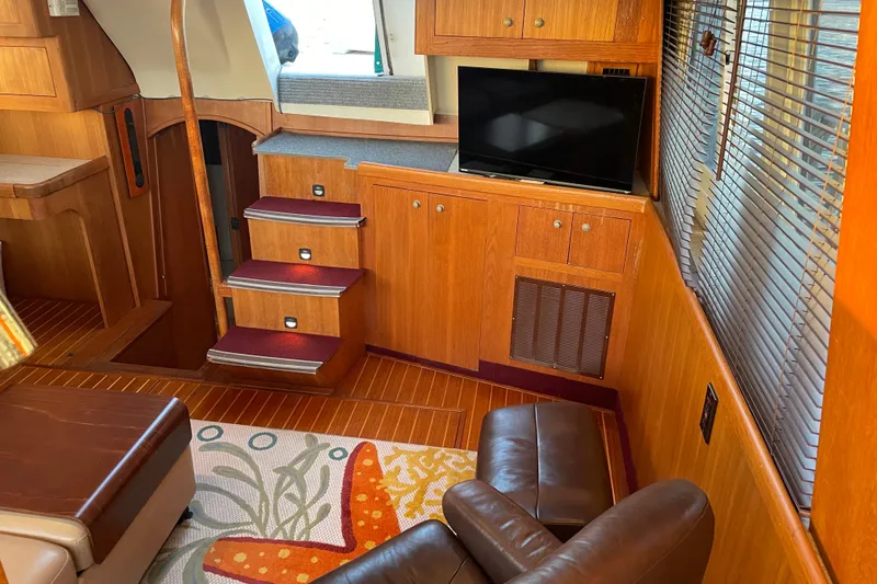 Mary Jean Too Yacht Photos Pics Interior of 2003 Mainship 430 Trawler with wooden cabinetry, TV, and leather seating.