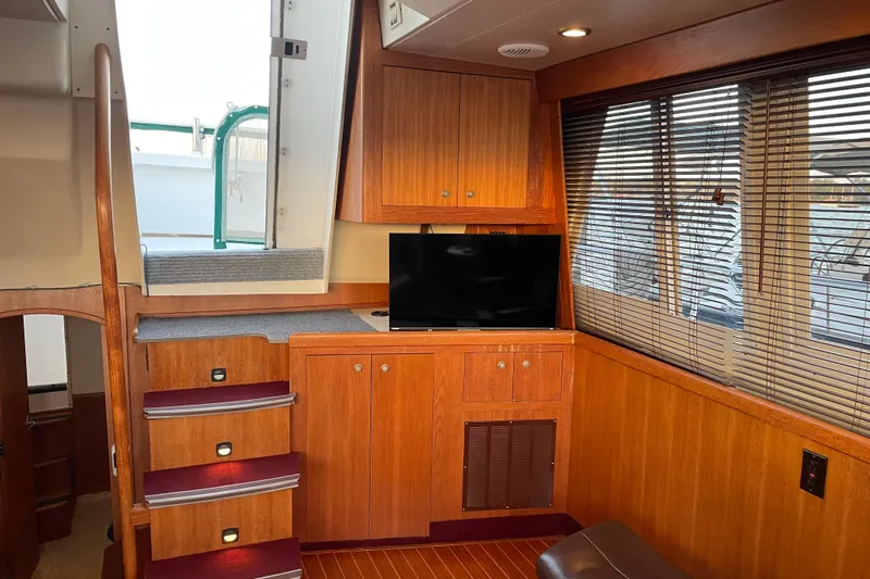 Mary Jean Too Yacht Photos Pics Interior of 2003 Mainship 430 Trawler with wooden cabinetry and a small TV.