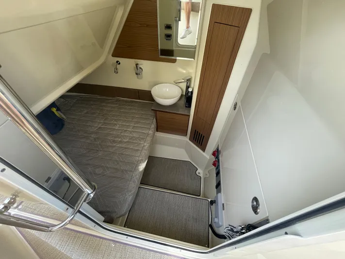  Yacht Photos Pics 2022 Chris-Craft Catalina 30 cabin interior with bed, sink, and wooden accents.