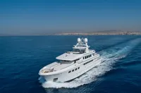Luxurious 2004 R.B Dereli yacht cruising on open sea with cityscape background.
