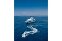 Luxurious R.B Dereli 2004 yacht cruising in open sea with small boats nearby.