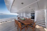 Luxurious yacht deck with dining area, wooden table, and ocean view, R.B Dereli 2004 model.