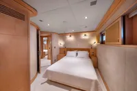Luxurious yacht bedroom with modern wood paneling, soft lighting, and a comfortable double bed.