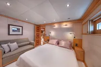Luxurious yacht bedroom interior with elegant decor, featuring a comfortable bed and sofa, R.B Dereli 2004.