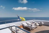 Luxurious yacht deck with sun loungers, ocean view, and flag, R.B Dereli 2004 model.