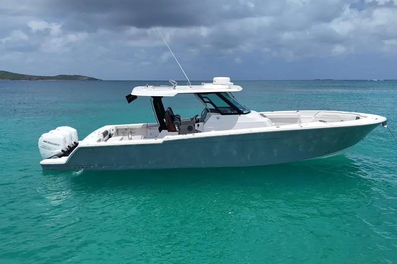  Yacht Photos Pics 2022 Bertram 39 CC boat on turquoise water under cloudy sky.