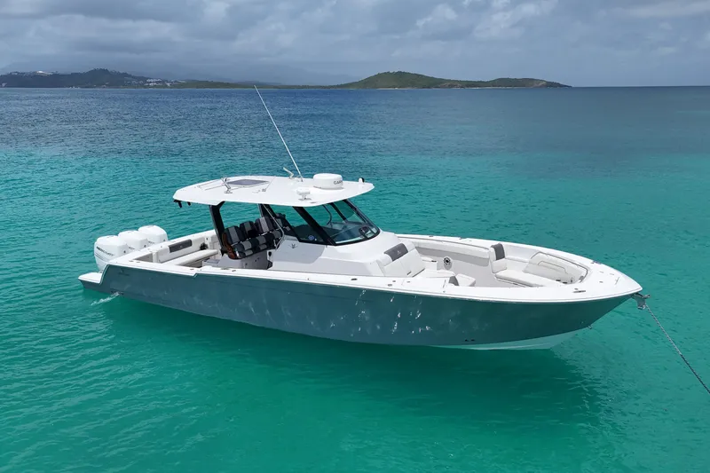  Yacht Photos Pics 2022 Bertram 39 CC boat anchored in clear turquoise waters.