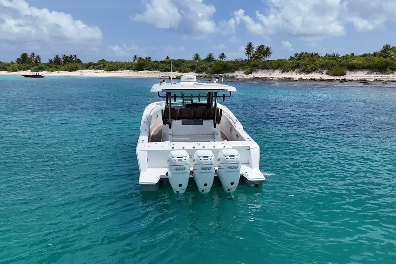  Yacht Photos Pics 2022 Bertram 39 CC boat with four engines in tropical waters near a sandy beach.