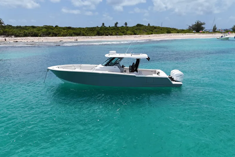  Yacht Photos Pics 2022 Bertram 39 CC boat on turquoise water near a sandy beach.