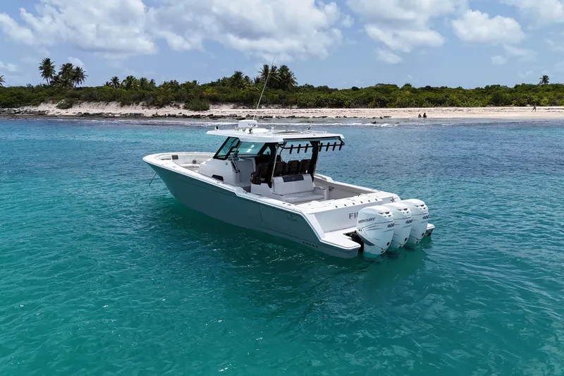 Yacht Photos Pics 2022 Bertram 39 CC boat in turquoise waters near a tropical beach.