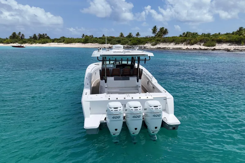  Yacht Photos Pics 2022 Bertram 39 CC boat with triple 400 engines in clear turquoise water near a tropical beach.