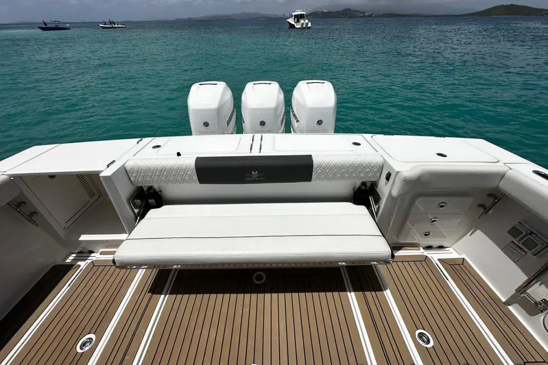  Yacht Photos Pics 2022 Bertram 39 CC boat with triple engines, teak deck, and seating, on calm water.