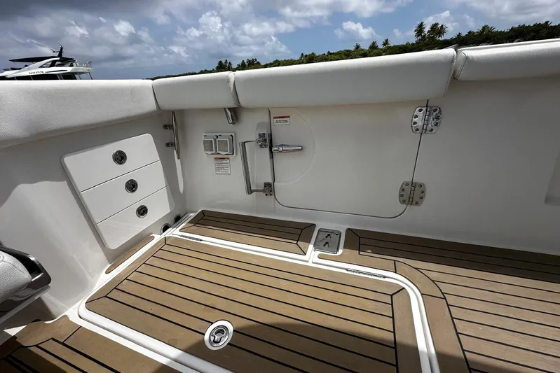  Yacht Photos Pics 2022 Bertram 39 CC boat deck with teak flooring and storage compartments.