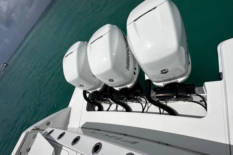  Yacht Photos Pics 2022 Bertram 39 CC boat with triple Mercury outboard engines on turquoise water.