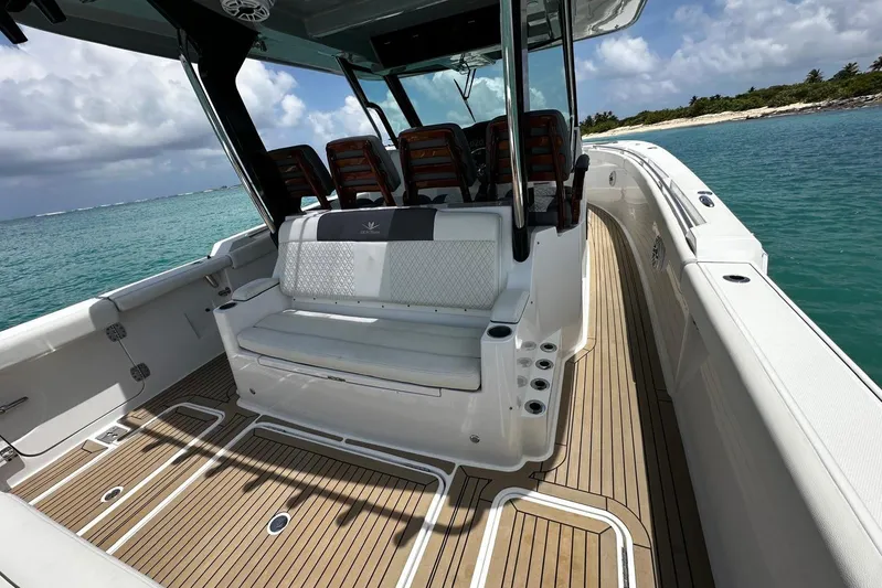  Yacht Photos Pics 2022 Bertram 39 CC boat interior with seating, on clear blue water, under cloudy sky.