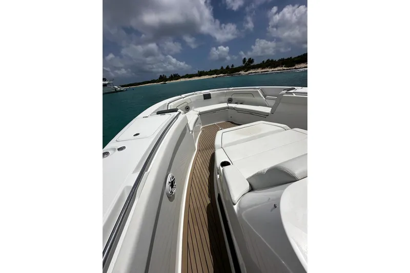  Yacht Photos Pics 2022 Bertram 39 CC boat deck with white seating, ocean view, and cloudy sky.