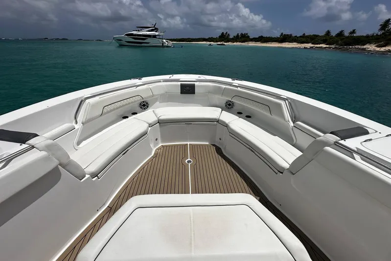  Yacht Photos Pics 2022 Bertram 39 CC boat with spacious seating, anchored near a tropical shoreline.