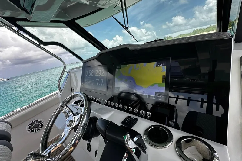  Yacht Photos Pics 2022 Bertram 39 CC boat cockpit with navigation screens and steering wheel.